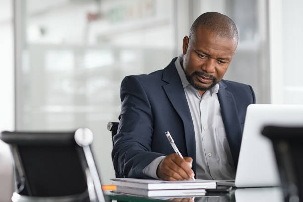 Businessman working and writing notes in office