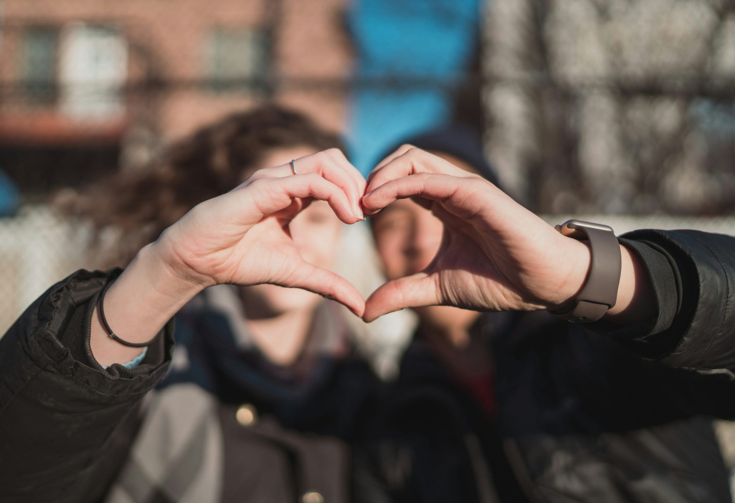 Two people forming heart hand shape