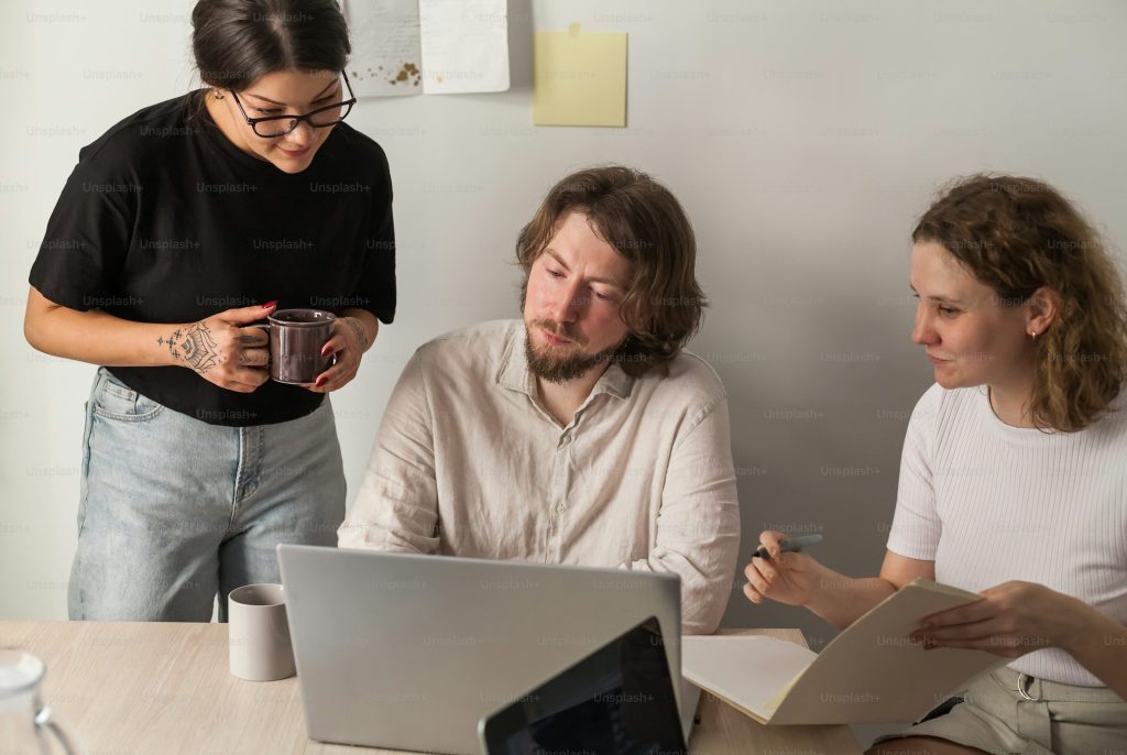 man and woman sitting at table using laptop computer