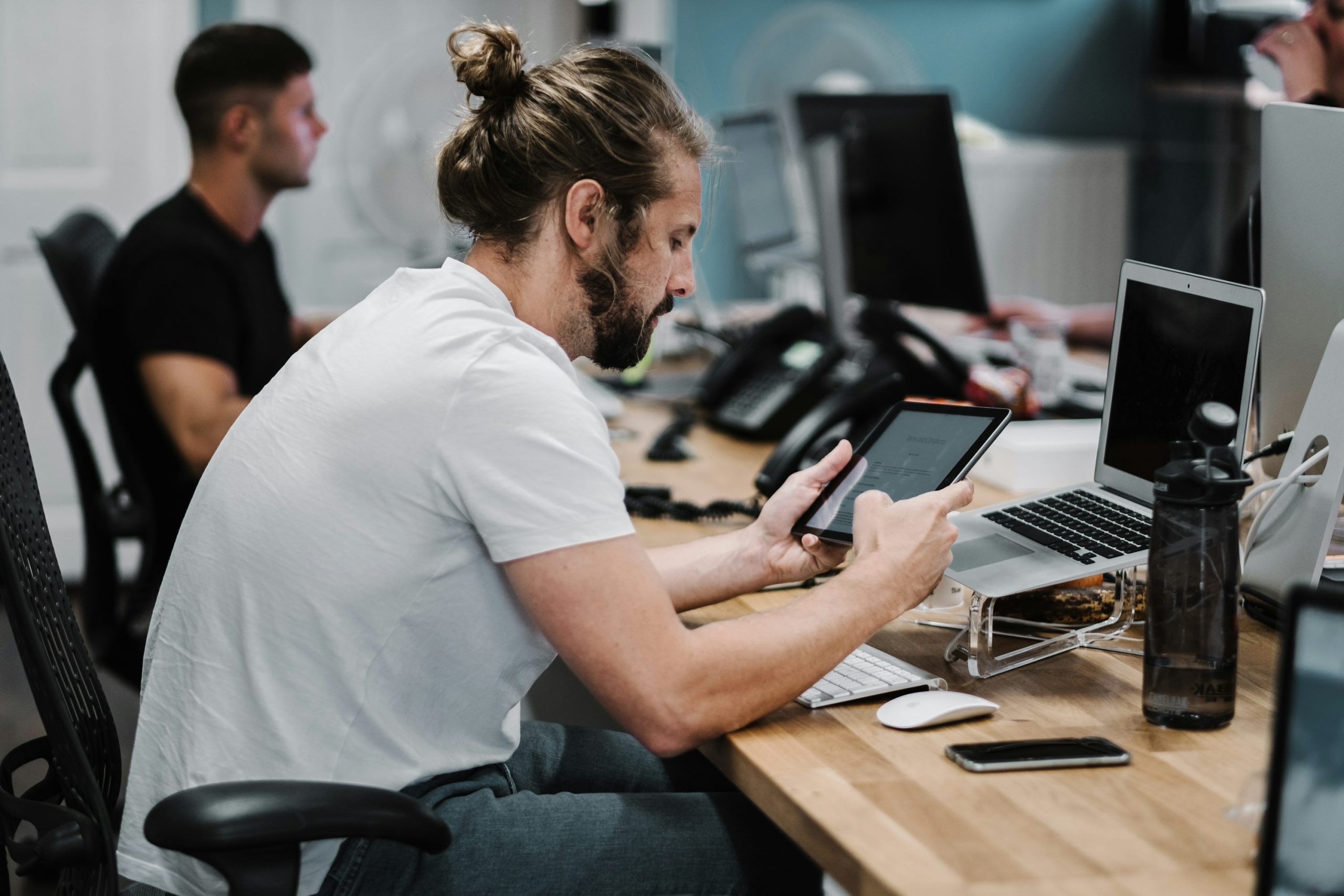 man sitting on chair beside laptop computer and teacup