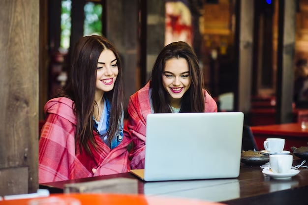 two women using laptops